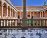 Dos niñas contemplan la arquitectura de un patio toledano. ¿Qué hacer hoy en Toledo? Explorar este lugar histórico.