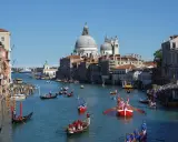 La Regata Storica anime le eaux de Venise, avec des gondoles et des bateaux traditionnels en compétition, sous le regard de la basilique Santa Maria della Salute.