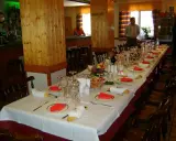 Mesa larga y elegante lista para comer en Riopar, con copas, platos y panecillos.