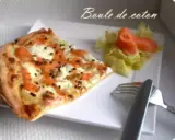 Une part de flamenkuch saumon, garnie de fromage frais et d'aneth, accompagnée d'une salade verte et de saumon fumé.