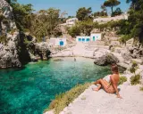 Una ragazza ammira la baia cristallina. Perfetto per decidere cosa fare stasera in Puglia: un tuffo rinfrescante!