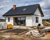Budowa domu w toku: bloczki, cement, zbrojenie i betoniarka. Zastanawiasz się, ile kosztuje pozwolenie na budowę?