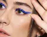 Ojos azules y piel blanca realzados con un audaz delineado azul eléctrico.