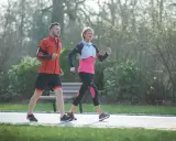 Ein Mann und eine Frau machen zügig **power walking** im Park.