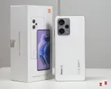 Biały smartfon Xiaomi Redmi Note 12 Pro+ 5G obok swojego opakowania.