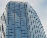 Trabajadores en altura limpian ventanas de edificio moderno. Sikaflex para que sirve: sellar y unir, asegurando la integridad de estas estructuras.