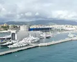 Porto con yacht di lusso ormeggiati, sullo sfondo la città e le montagne. Un'immagine che fa sognare, ma il costo medio crociera è da valutare.