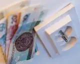 Pieniądze leżą obok gniazdka elektrycznego. Czy to symbolizuje pge brak faktury i rachunków do zapłaty?