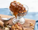 En skål med chokladglass, toppad med kolasås och nötter. Perfekt för ett chokladglass recept!