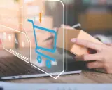 Wizualizacja procesu sprzedaży online. Widoczny laptop, ręce trzymające paczkę i ikony koszyka. To pokazuje, jak działa Baselinker.