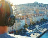 Personne avec des écouteurs, profitant de la musique persane face à une ville ensoleillée.