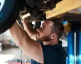 Mechanik sprawdza zawieszenie auta na podnośniku. Dowiedz się, ile kosztuje sprawdzenie zawieszenia na stacji diagnostycznej.