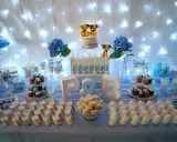 Mesa de dulces para una boda sencillo: pastel con perritos, cupcakes, macarons y postres individuales.