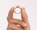 Dita che mostrano un anello in oro 18k 0.750, un gioiello elegante e moderno.