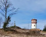 Wieża widokowa i krzyż na wzgórzu w Górach Opawskich. Szlaki prowadzą przez suchą trawę i nagie drzewa.