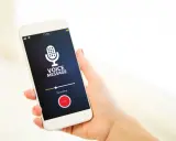 Dyktafon w telefonie nagrywa wiadomość głosową. Ikona mikrofonu i przycisk "Stop" są widoczne na ekranie.