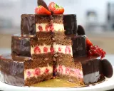 Gâteau à trois étages au chocolat et aux framboises, parfait pour une recette gâteau anniversaire facile. Décoré de fruits rouges et de chocolat.