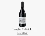 En flaska Bel Colle Langhe Nebbiolo, ett utsökt italienskt vin med en vacker etikett som föreställer ett träd.