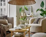 Przytulny salon w stylu skandynawskim z wygodną sofą, puszystym fotelem i drewnianym stolikiem kawowym.