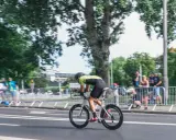 Kolarz w stroju sportowym ściga się na rowerze aerodynamicznym. Myślę, jak sprzedać rower, gdy widzę takie osiągi.