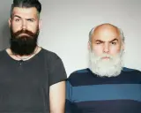 Dwóch mężczyzn z brodami. Jeden z nich ma ciemną, gęstą brodę i zastanawia się, jak zagęścić brodę. Drugi ma siwą, bujną brodę.