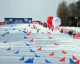 Zawodnicy snowboardu pokonują trasę z czerwonymi i niebieskimi tyczkami na stoku Jaworzyny Krynickiej.