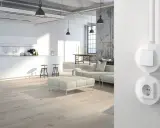 Moderne Küche mit weißen Fronten und Holzboden. Steckdosen planen für ein stilvolles Ambiente.