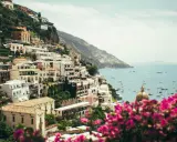 Positano, uno dei paesi più belli della Costiera Amalfitana, con case bianche aggrappate alla scogliera e il mare blu pieno di barche.