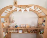 Ein liebevoll gestalteter Kaufladen zum selber bauen, gefüllt mit Spielzeug-Lebensmitteln wie Wurst, Käse, Zucker und Milch.