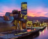 Zachód słońca nad rzeką w Euskadi, z Muzeum Guggenheima i wieżowcem Iberdrola w tle.