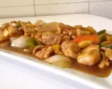 Delicioso pollo con almendras, pimientos y cebolla en una salsa dorada.