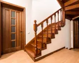 Scala interna in legno scuro con porte abbinate. Idee pittura scala interna: il legno caldo crea un'atmosfera accogliente.