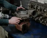 Mechanik trzyma turbosprężarkę, przygotowując się do wymiany zaworu N75.