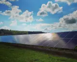 Lång rad solpaneler fångar solljuset under en molnig himmel. Solkraft EMK AB bidrar till en grönare framtid.