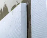Aislamiento de poliestireno expandido en una pared, paso clave para **edificios eficientes** y confortables.