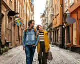 Ein Paar spaziert durch eine Gasse in Stockholm. Das Wetter in Schweden im September ist mild, perfekt für Sightseeing.