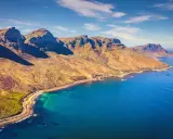 Bergige Küste bei Kapstadt mit türkisfarbenem Wasser und einem einsamen Strand.