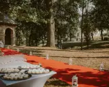 Czerwony dywan prowadzi do pałacu w Małkowie, ozdobiony lampionami i stołem z przekąskami.