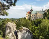Zamek Hrubá Skála, wspaniały przykład tego, co warto zobaczyć w Czechach, wznosi się nad skalistym krajobrazem i bujną zielenią.