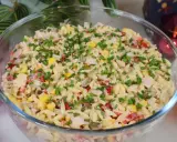 Pyszna sałatka z makaronem orzo, kukurydzą, papryką i kurczakiem, posypana szczypiorkiem. Idealna na letnie dni.