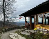 Bacówka pod Wierchomlą, schronisko górskie PTTK z widokiem na góry. Polska flaga powiewa nad wejściem.