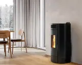 Poêle à granulés noir moderne, offrant une puissance de chauffage idéale pour un salon cosy. La flamme visible promet une ambiance chaleureuse.