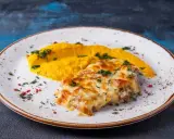 Schab po zbójnicku z purée z dyni, posypany zieloną pietruszką i czerwonym pieprzem.