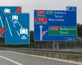 Znaki drogowe na autostradzie: kamery, kierunki do Gdańska, Torunia, Warszawy, Bydgoszczy. Ograniczenie 60 km/h.