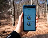 Telefon z aplikacją Ratunek Plus, pokazującą opcje "Woda" i "Góry". Idealny do sytuacji awaryjnych, gdy potrzebny jest gopr numer.