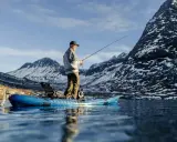Man fiskar från en kajak i en fjällsjö. Frågan är hur långt paddlar man på en dag i sådan vacker natur?