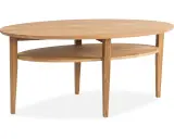 Ett elegant, ovalt soffbord i ek med en praktisk avlastningshylla. Perfekt för att förvara tidningar eller fjärrkontroller.