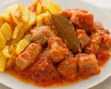 Sabroso magro con tomate, trozos de carne tierna en salsa de tomate, acompañados de patatas fritas doradas.