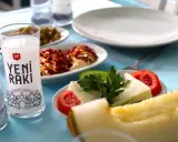 Ein Glas Yeni Raki, Käse, Tomaten und Melone – so trinkt man Raki in geselliger Runde.