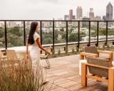 Frauen auf einer Dachterrasse mit Blick auf eine Stadt der kurzen Wege. Moderne Möbel laden zum Verweilen ein.